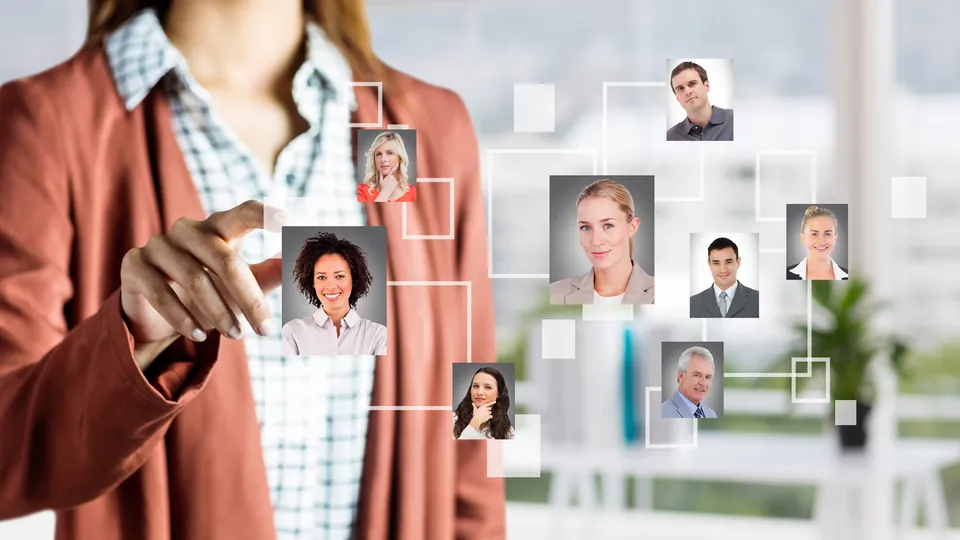 A recruiter's hand selecting a candidate from a connected network of professional headshots